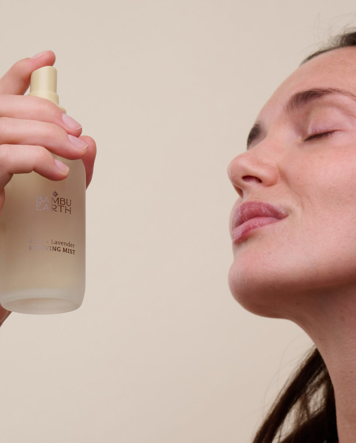 Woman misting her face with Rose + Lavender Reviving Mist