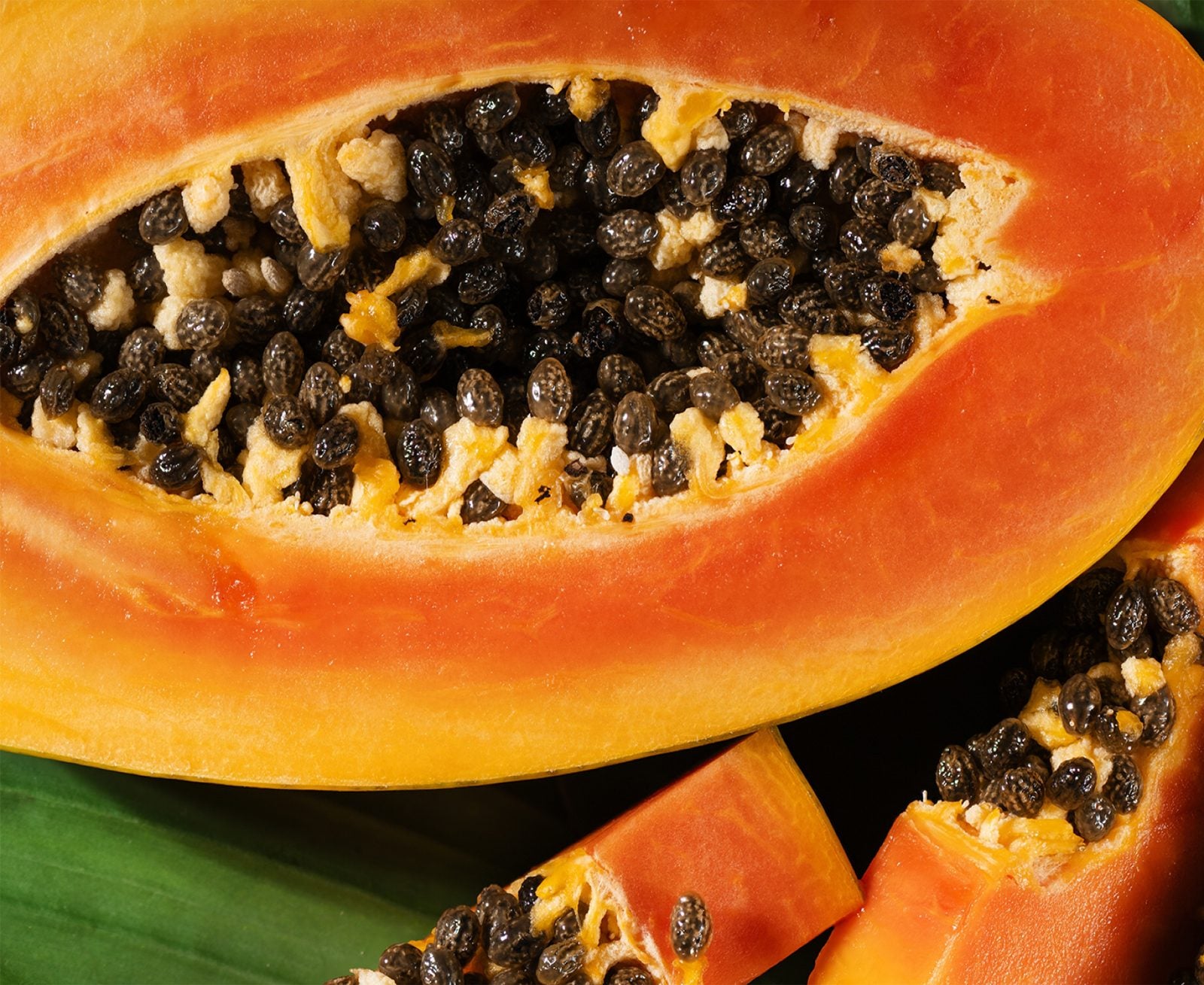 Halved papaya on a banana leaf