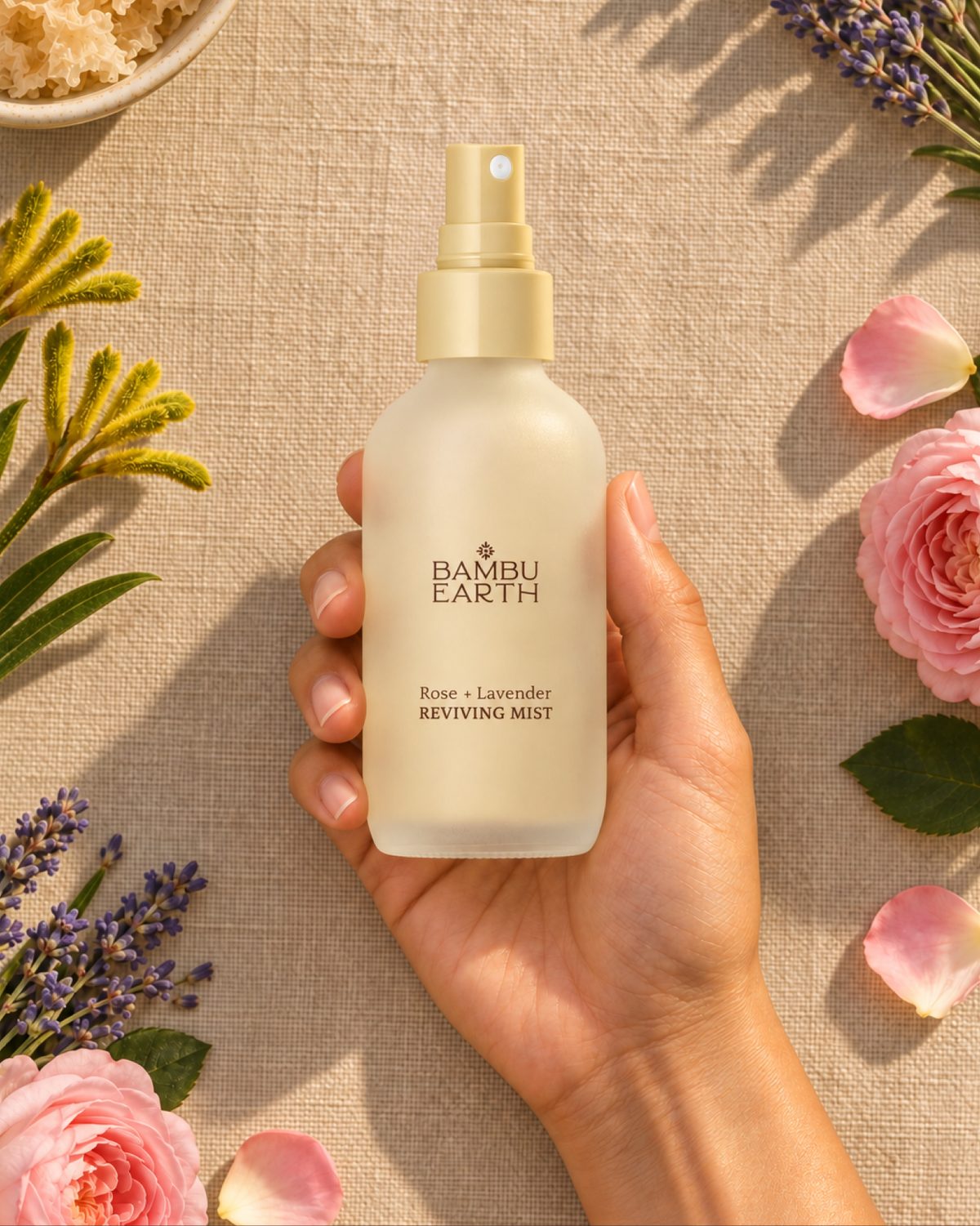Rose + Lavender Reviving Mist held among roses, lavender and kangaroo paw