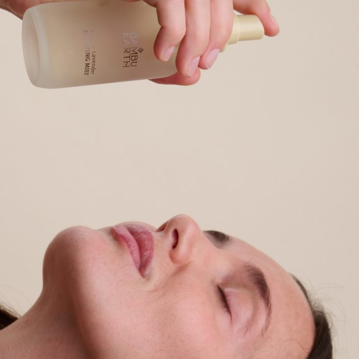 Esthetician misting the client's face with Rose + Lavender Reviving Mist