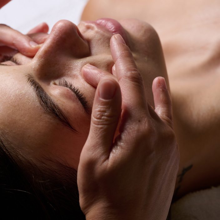 Esthetician pressing serum into freshly misted skin